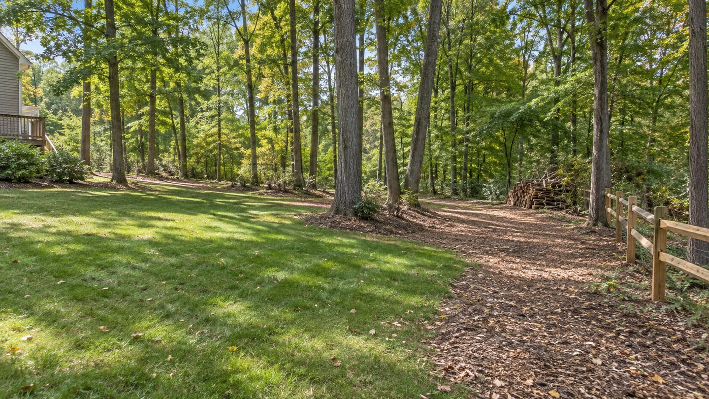 A cleared woodland lawn edge and clean access path at a residential property.